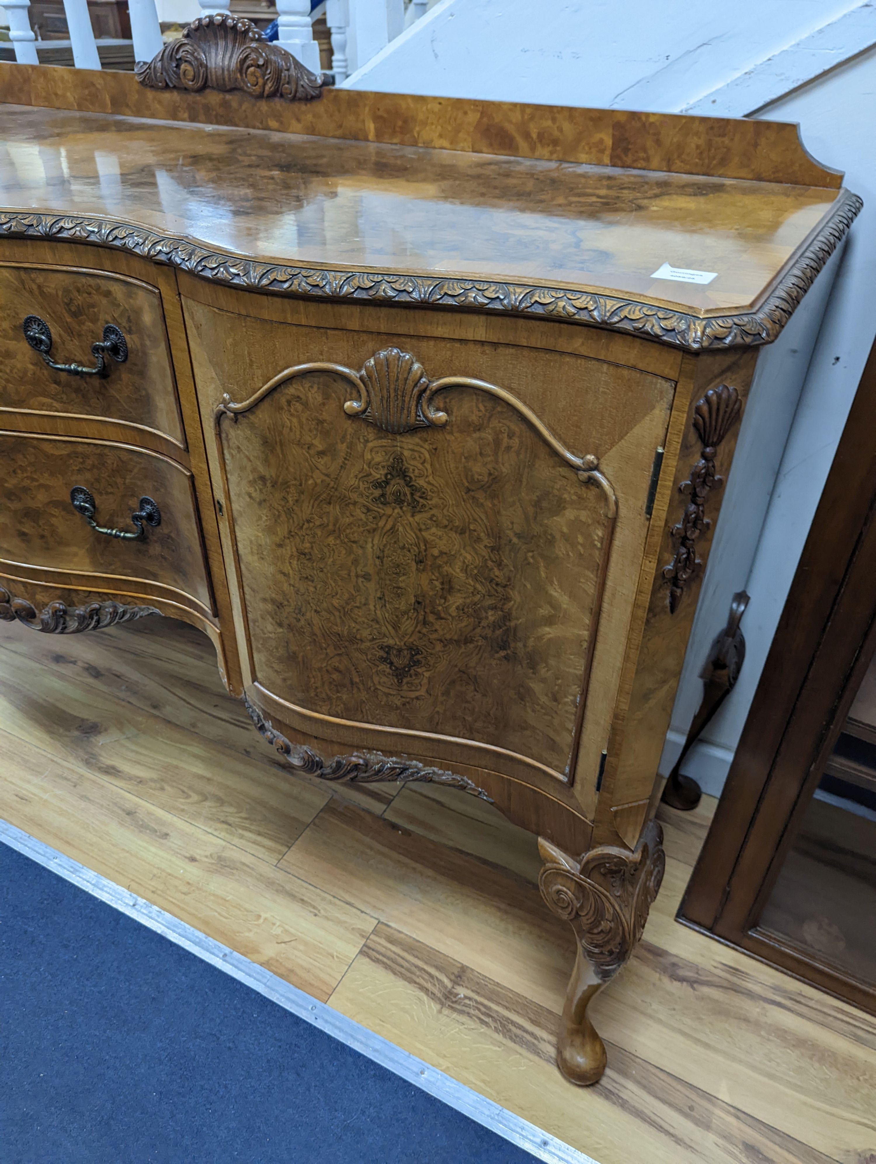 A Queen Anne revival burr walnut dining suite, comprising serpentine sideboard, length 168cm, depth 56cm, height 98cm, extending dining table, 210cm extended, one spare leaf, width 90cm, height 75cm and eight chairs, two